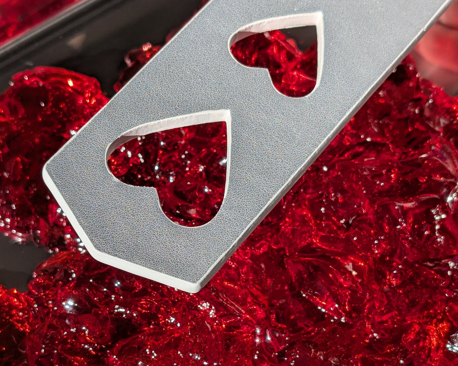 Metallic card with hearts on a red jelly-like surface